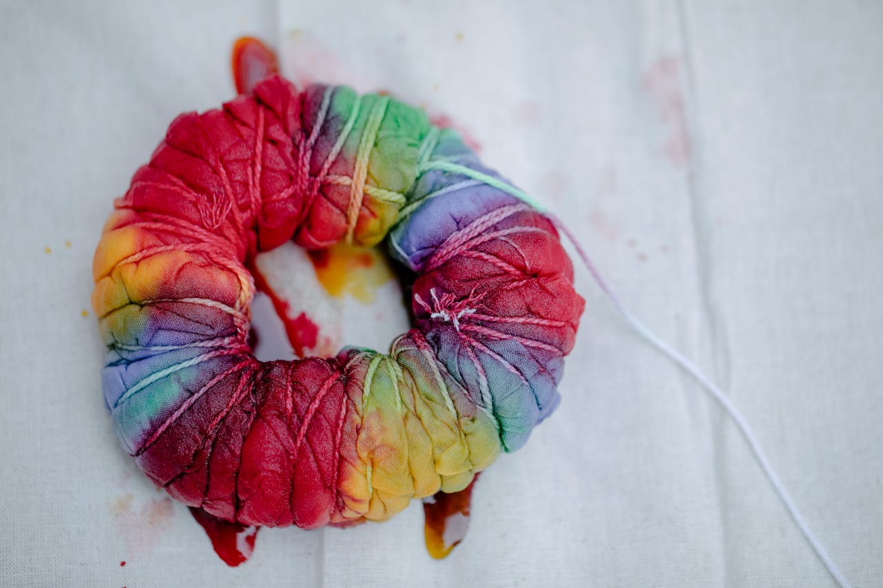 Folded fabric with colorful paints on white background